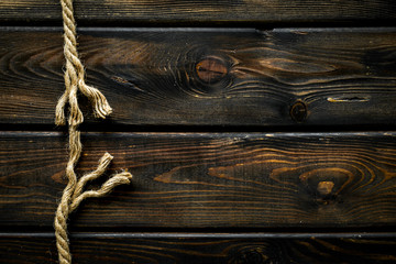 Tearing the rope under stress on wooden background top view copyspace