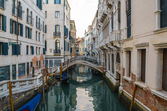 Boats on narrow canal between colorful historic houses in Venice. © k_samurkas