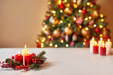 Christmas decor with candles on a table against the background of the Christmas tree