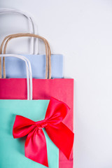 Christmas shopping and sale concept. Buying Christmas gifts. Pastel colored paper bags with xmas  and New Year gifts. On white background copy space