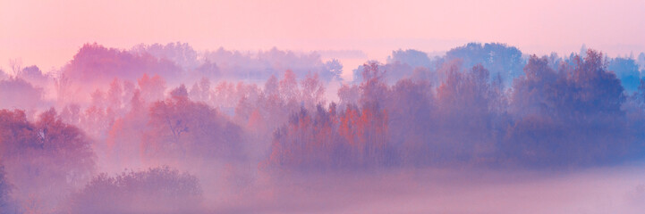 Banner 3:1. Close-up scenic foggy autumn landscape at sunrise. Aerial view on countryside. Colorful autumnal background. Soft focus