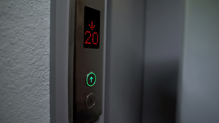 Electronic LCD elevator display showing twenty floor down, automatic system