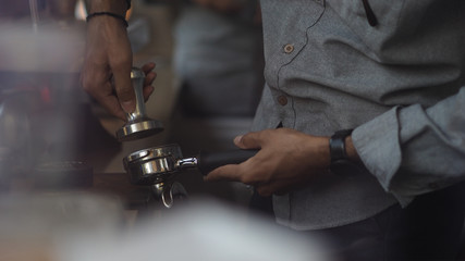 Close up of a male barista hand preparing to make a cup of coffee. Selected focus. Wide aspect...