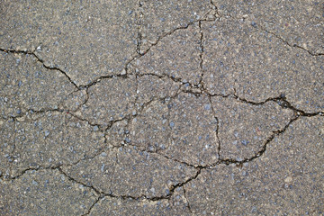 ひび割れた古い舗装道路の表面