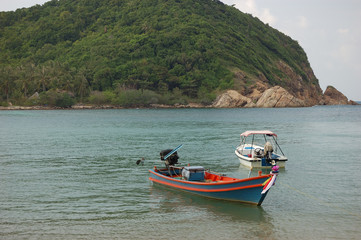 Fototapeta na wymiar Two boats facing the Koh Ma island at Mae Haad Beach, Koh Phangan, Thailand