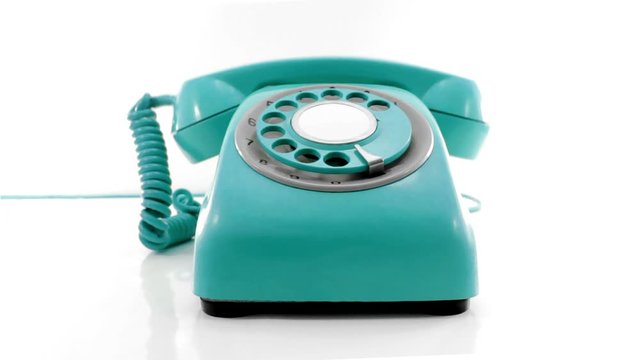 a retro turquoise phone ringing off the hook isolated on white