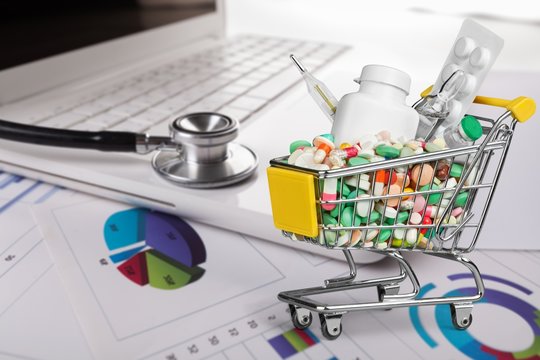 Shopping Cart with pills isolated on background
