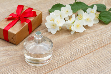 Fototapeta na wymiar Gift box with perfume and jasmine flowers on the background.
