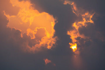 Fiery sunset. Bright orange sky and sun with clouds.
