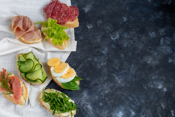 Sandwiches are triangular and oval. Vegetarian and more. Dressing with avocado and spinach and creamy yogurt. Top cucumber, turnips, tomatoes, salami, balyk, red caviar, spinach, eggs and olives. 