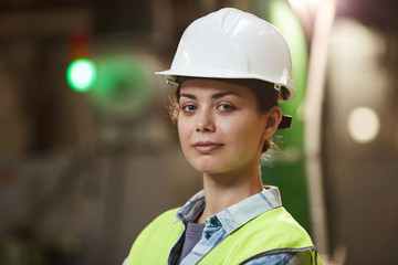 Portrait of young businesswoman in workwear looking at camera while standing in the plant