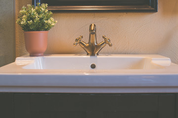 Front view of luxury faucet and white sink in restroom or bathroom for interior design.