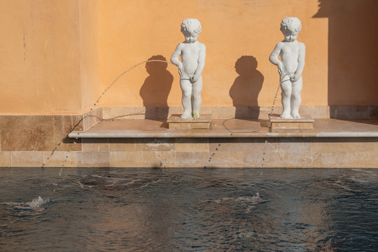 Abstract image of Shabby white statue or sculpture child standing and peeing or urine nearly swimming pool.