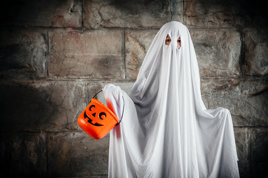 Bed sheet ghost with pumpkin bucket for Halloween