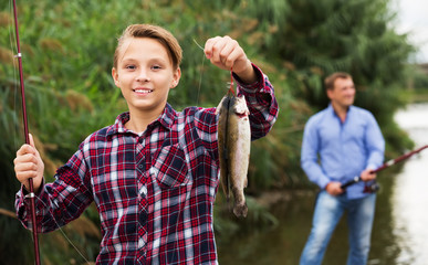 Fisher boy showing catch fish