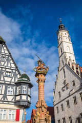Fototapeta na wymiar Georges spring pillar and Rathaus building at Marktplatz Rothenburg ob der Tauber Old Town Bavaria Germany