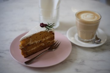 Cup of milk coffee with piece of cake
