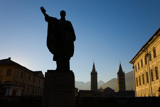 Statue of Saint Anselm and the towers of the Cathedral of Aosta, the Cattedrale di Aosta de Corso Pere-Laurent in Aosta. Aosta Valley. Italy. Europe