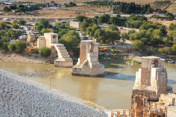 Fototapeta premium Panoramic view of the Old Tigris Bridge, Castle and minaret in the city of Hasankeyf, Turkey. Batman, Mardin Province