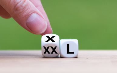 Reducing weight concept. Hand turns a dice and changes the expression "XX-L" to "X-L".