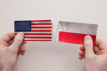 USA and Poland paper flags ripped apart. political relationship concept