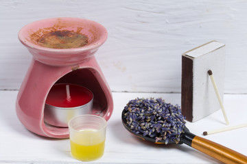 Lavender flowers in a spoon next to the aroma lamp. Oil is poured into the cap. Natural pharmacy. Aromatherapy with natural oils.