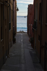 Old alley on the sea. Characteristic narrow alley with sea in background.