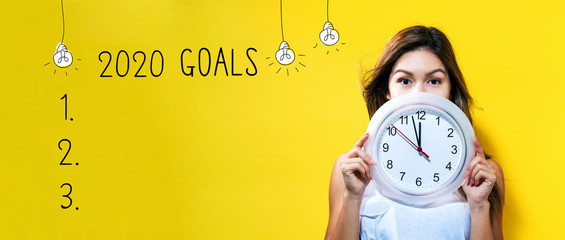 2020 goals with young woman holding a clock showing nearly 12