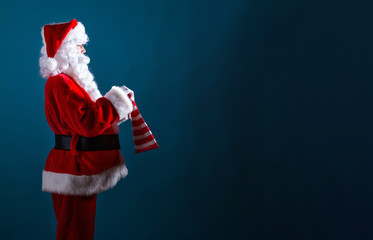 Santa holding a shopping bag on a dark blue background