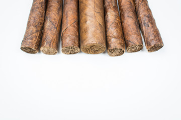 Big and small cigars twisted from sheets of tobacco on white background.
