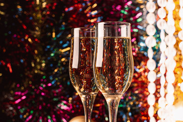 Champagne in glass goblets close-up on a sparkling festive background. New year christmas concept. Horizontal frame.