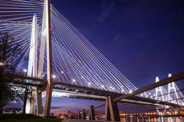 Obraz premium Nocna panorama mostu nad rzeką z sylwetką zakochanej pary.