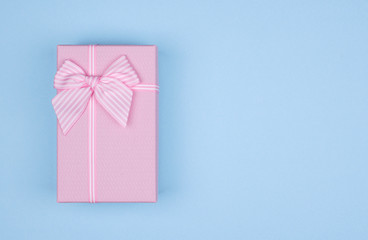 Pink rectangular gift box with pink ribbon on blue background. gift for March 8, Valentine's day, birthday. Top view. Copy space