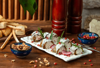 aubergine wrap stuffed with cream and walnut garnished with yoghurt sauce