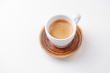 Cup of coffee on white paper background. Close up. Copy space.