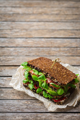 Fresh rye bread sandwich with ham, lettuce and tomato