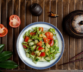 fresh vegetable salad with lettuce, tomato and cucumber garnished with sauce