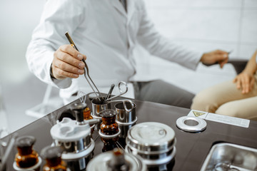 Otolaryngologist taking medical tweezers from the ENT workstation during a procedure, close-up view