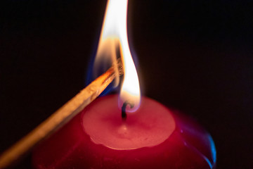 Mit Streichholz entzündete Kerzen erleuchten die dunkle Adventszeit in der Vorweihnachtszeit und...
