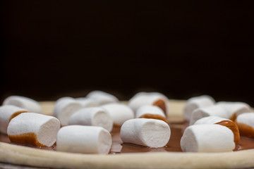 Pizza. Raw dough. Top view.  Sweet pieces of pizza with murshmello and nutella. Black and white backgrond. Taste piece. 