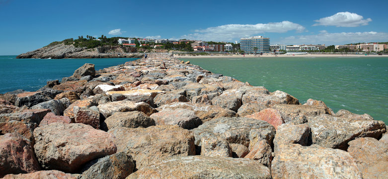 Panoramic view of the seaside with a stone breakwater. La Pineda, Spain.