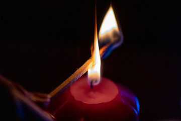 Mit Streichholz entzündete Kerzen erleuchten die dunkle Adventszeit in der Vorweihnachtszeit und...