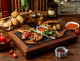grilled whole chicken served with tomato sauce on stone board