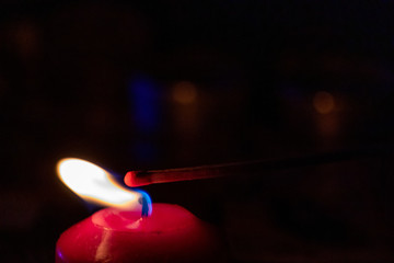 Mit Streichholz entzündete Kerzen erleuchten die dunkle Adventszeit in der Vorweihnachtszeit und...