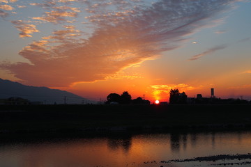 Fototapeta premium 川越しに見える夕日の様子