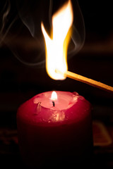 Mit Streichholz entzündete Kerzen erleuchten die dunkle Adventszeit in der Vorweihnachtszeit und...