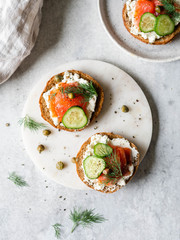 Several sandwiches on rye bread with cream cheese, salmon, fresh cucumber and spices. Top view