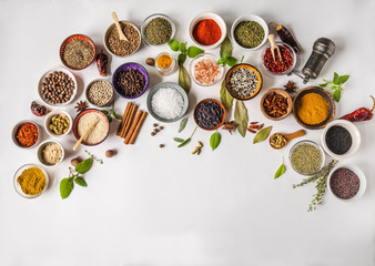 Fototapeta na wymiar Various dry spices in small bowls and raw herbs flat lay on white background. Top view,
