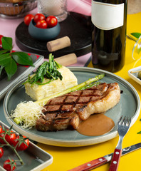 lamb steak garnished with sauce, served with asparagus, parmesan and sauteed spinach