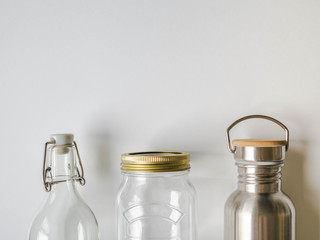 Items for purchase or storage of various liquids. Glass bottle, metal bottle and glass jar on a...